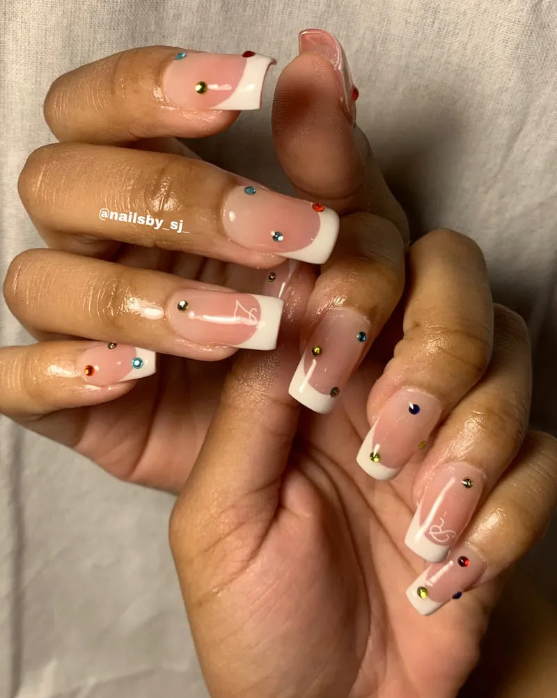 Short square French nails on blush bases with small coloured studs and line-drawn bunnies