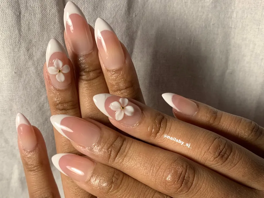 Close up of almond nails with fine French tips and tiny white flowers